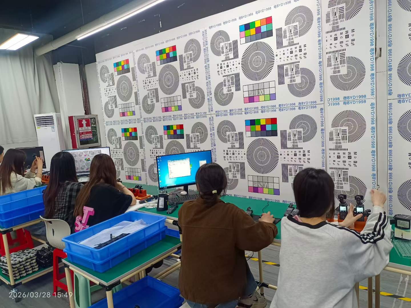 奥赛克影像检查现场，测试图卡覆盖工位前方，工作人员在工位上查机画面。